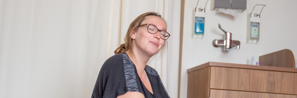 Een puffende vrouw wordt door de kraamverzorgende bij Kraamzorg Wijs Dronten stap voor stap geholpen om zich goed voor te bereiden op de bevalling